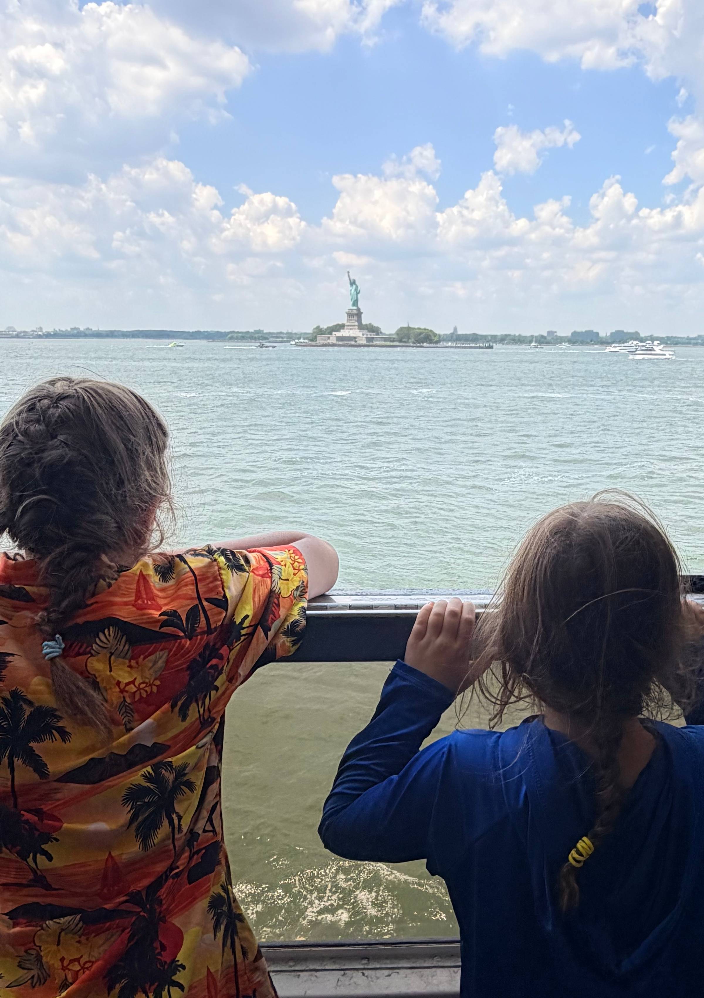 Two kids looking at the Statue of Liberty