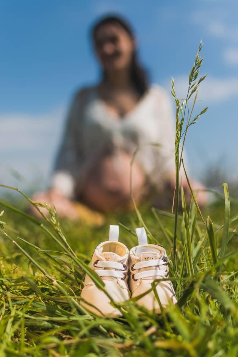 A pair of baby shoes sitting in the grass