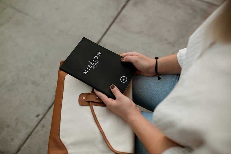 woman holding black Mission book