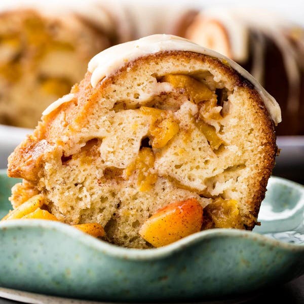 slice of Bundt cake with loads of peach chunks showing in the cake