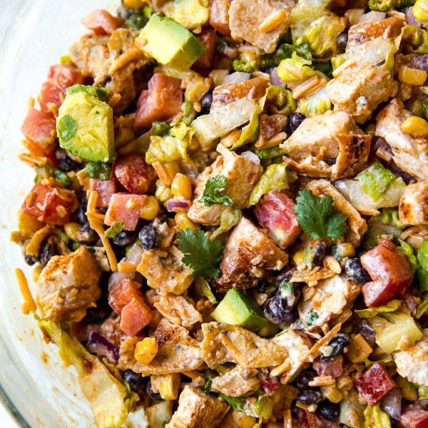 picture of a salad with chicken, avocado, tomatoes, black beans, and more