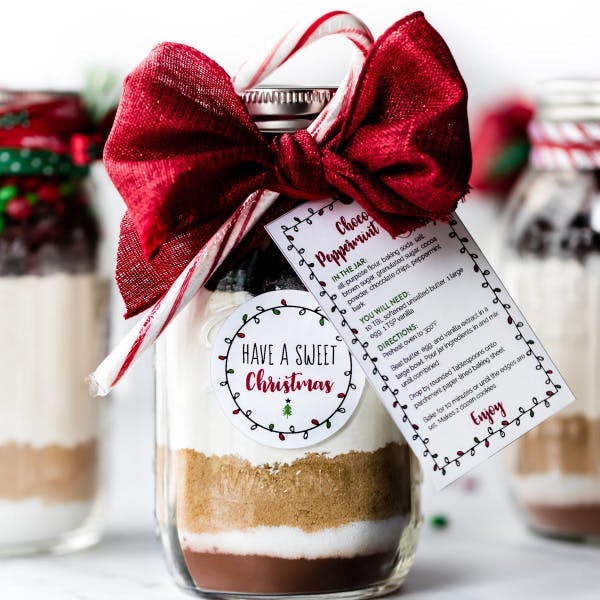 photo of giftable DIY cookies in a jar with red bow and candy cane