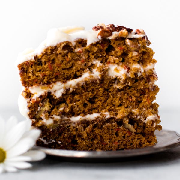 slice of three layer carrot cake with cream cheese frosting