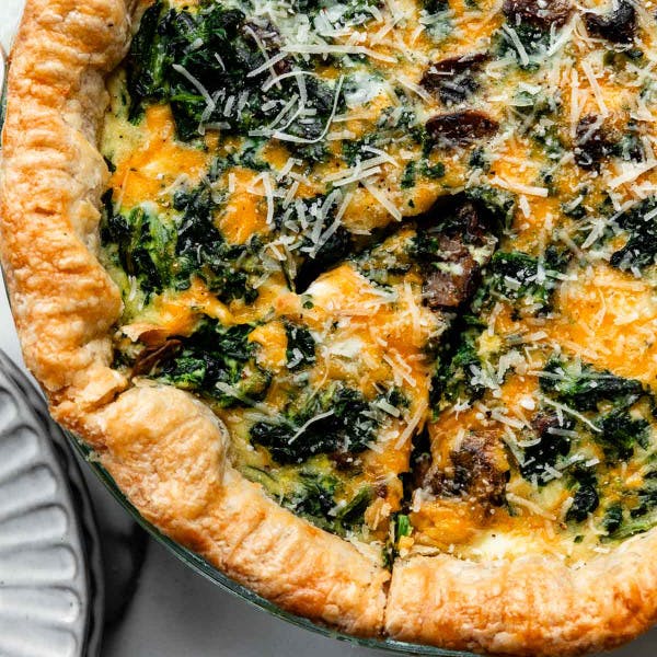 cheesy spinach quiche in a pie dish