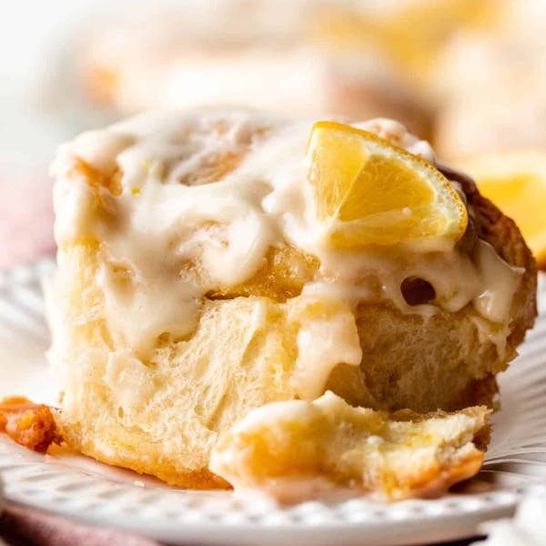 lemon sweet roll on a plate topped with icing