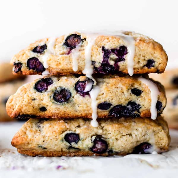 three blueberry scones, stacked, with vanilla icing