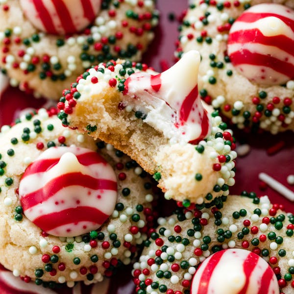 sugar cookies rolled in sprinkles and topped with candy cane Hershey's Kiss