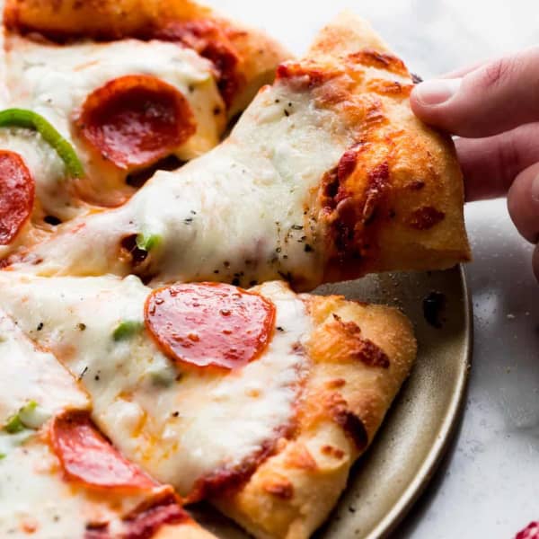sliced pepperoni pizza, with a slice being pulled away