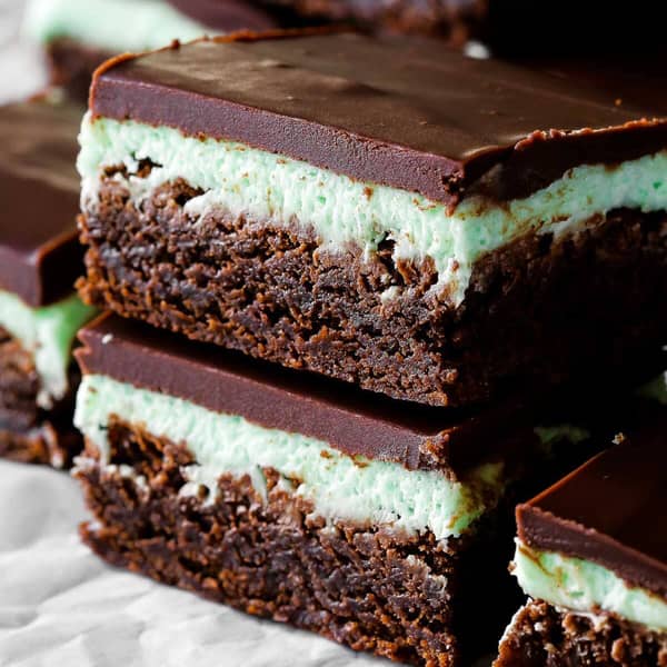 stack of two brownies with green frosting and chocolate ganache layered on top