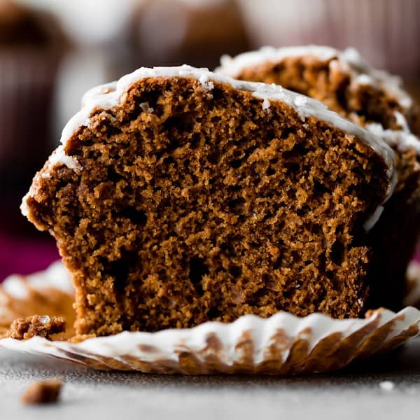 gingerbread muffin with glaze cut in half, showing the soft inside