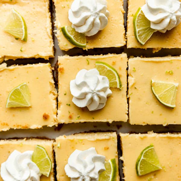 overhead photo of key lime pie bars with whipped cream on top of some
