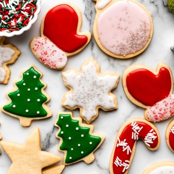 cut-out and decorated sugar cookies in the shapes of mittens, candy canes, snowflakes, and christmas trees