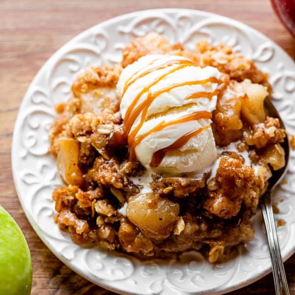apple crisp on a plate with ice cream and caramel
