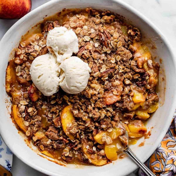 peach crisp with pecan streusel topping and vanilla ice cream