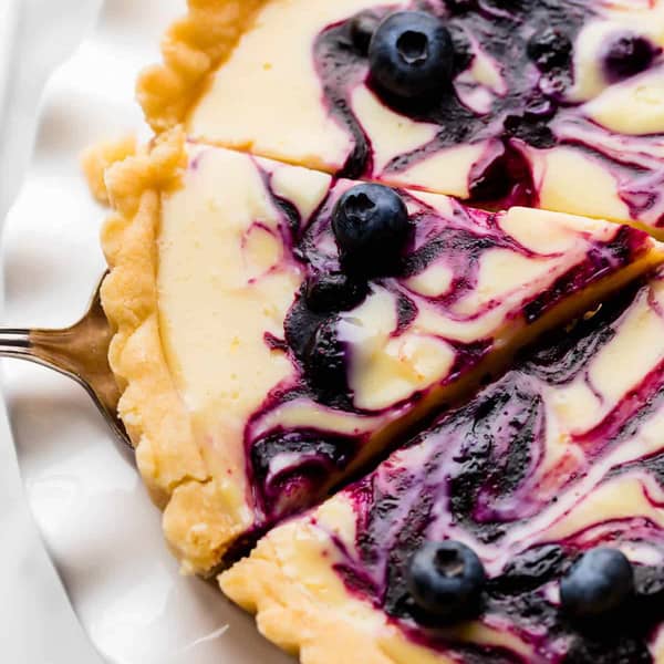 a slice of lemon tart with blue blueberry swrils