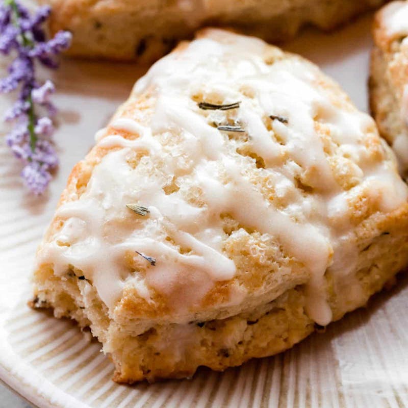 glazed scone on a white plate with a bite taken