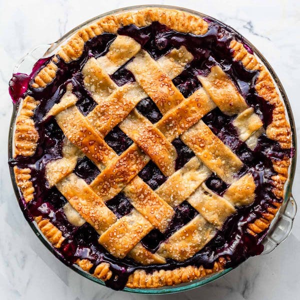 overhead view of a juicy blueberry pie with pie crust lattice