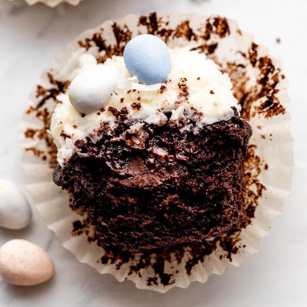 chocolate cupcake with chocolate filling and white frosting, with a bite taken out