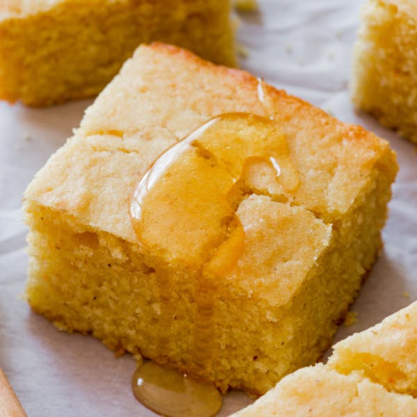 Slice of cornbread topped with honey