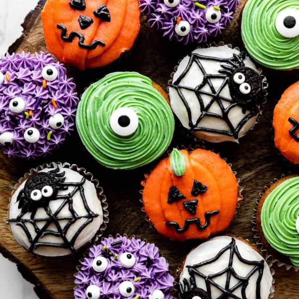 cupcakes decorated to look like monsters, pumpkins and spiders
