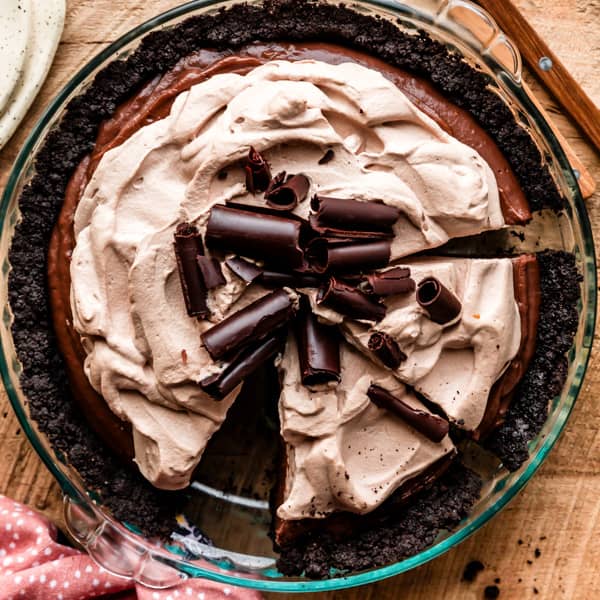 mocha pudding pie with whipped cream and chocolate curls on top