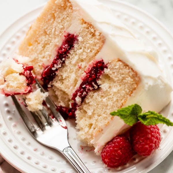 white cake with raspberry filling on a white plate