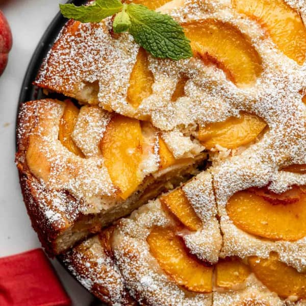 single layer cake with fresh peaches and powdered sugar