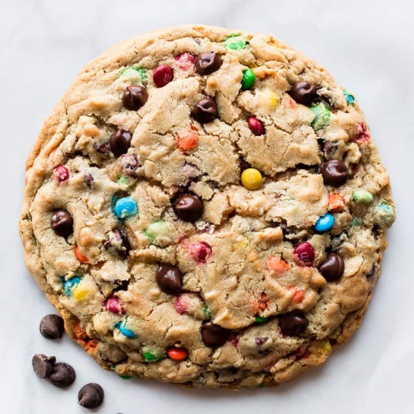 one giant monster m&m cookie on a white backdrop