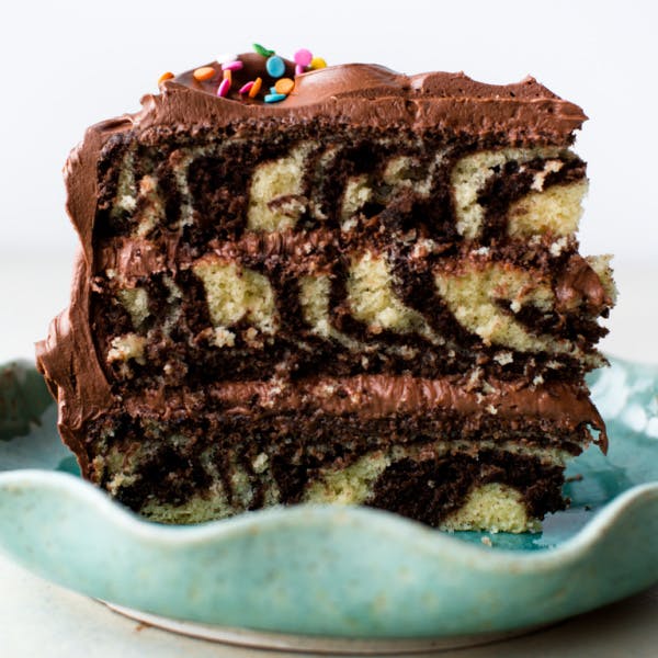 slice of three layer zebra cake with chocolate frosting