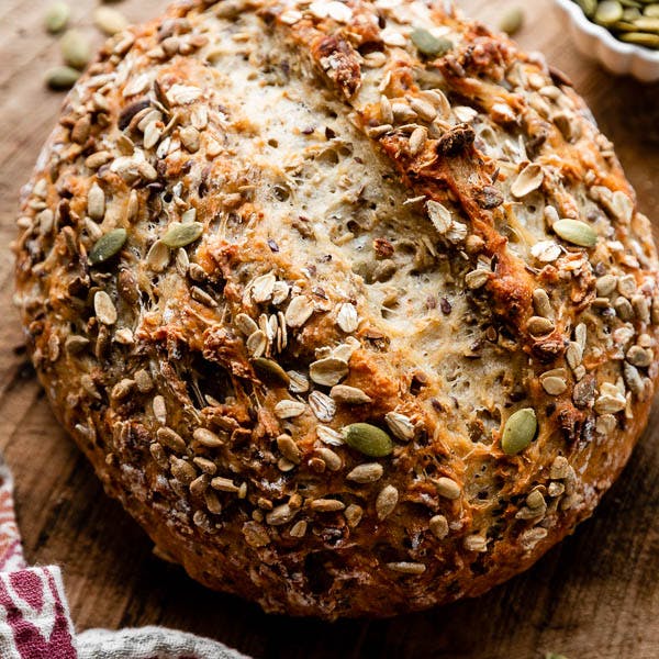 round load of seeded oat bread on a wood board