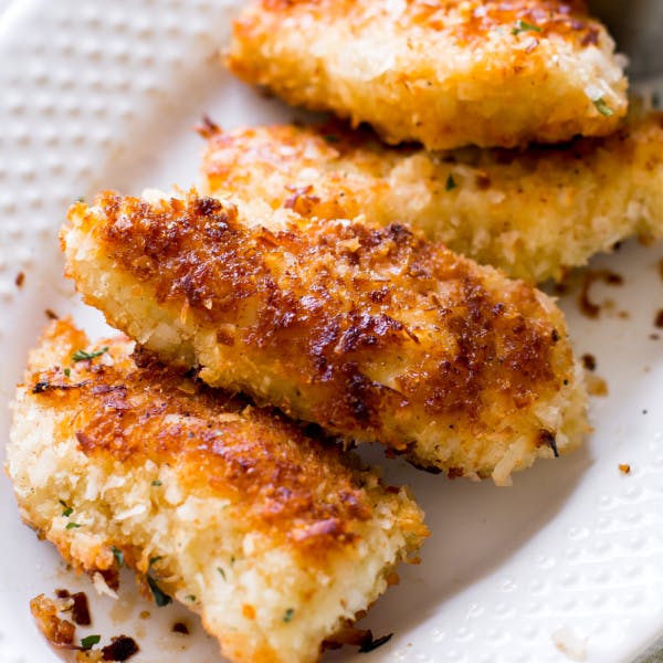 pieces of golden brown coconut chicken on a white plate