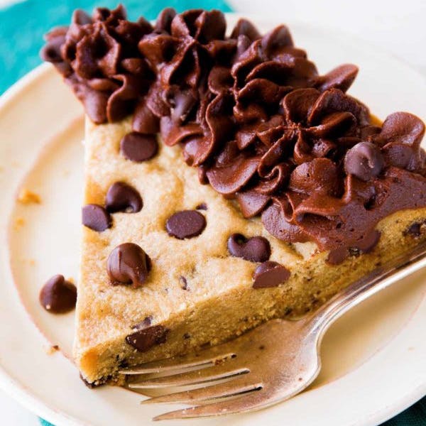 picture of a slice of chocolate chip cookie cake with chocolate buttercream frosting