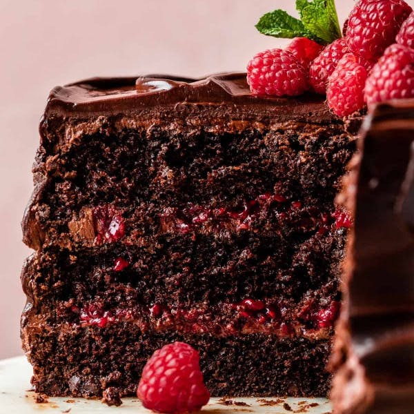 chocolate raspberry cake topped with chocolate ganache and fresh raspberries and mint