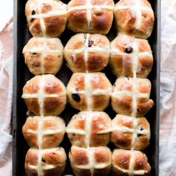 rolls with crosses on them in a metal baking dish
