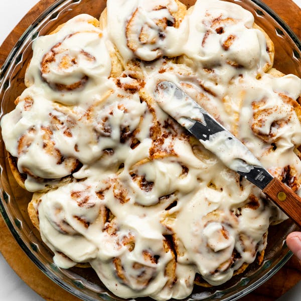 picture of a round pan of cinnamon rolls with icing