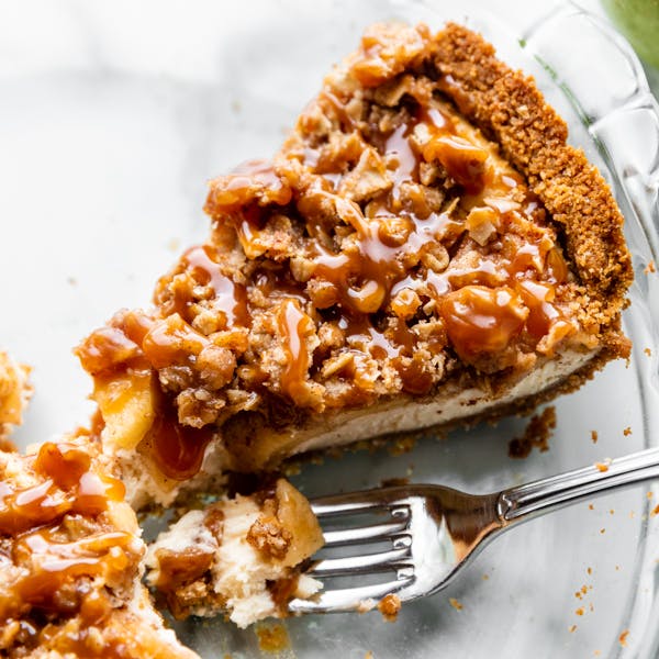 Caramel apple cheesecake pie slice in a pie dish