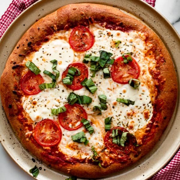 whole wheat pizza crust with cheese and tomatoes
