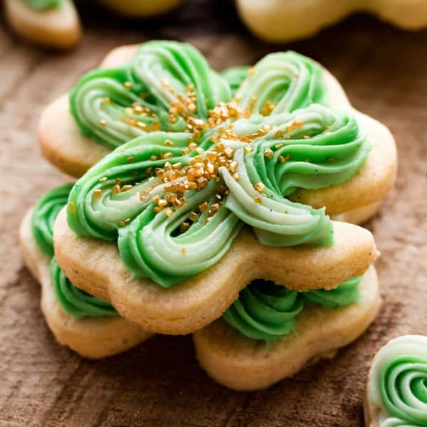 shamrock shaped sugar cookie with green frosting and gold sprinkles