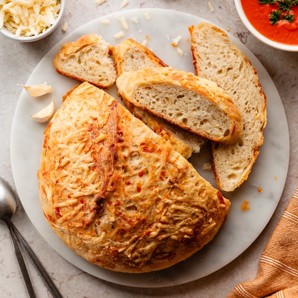 asiago bread boule and slices on marble platter