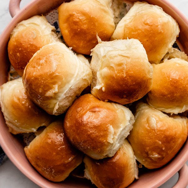 golden dinner rolls in a pink dish