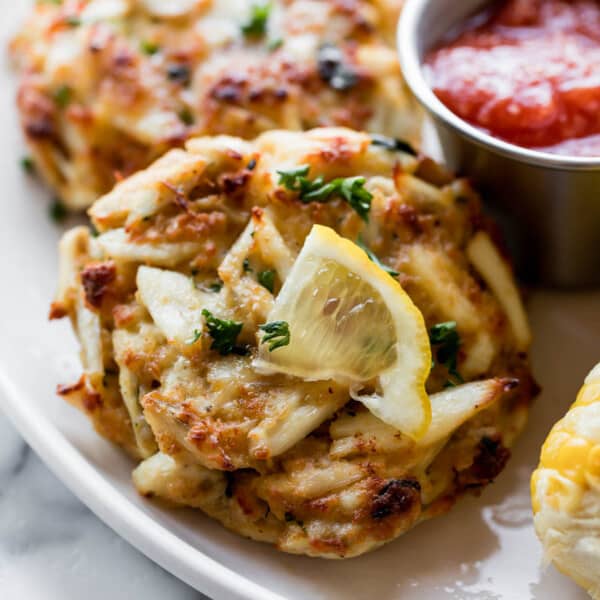 Picture of a crab cake on a plate with a lemon wedge 