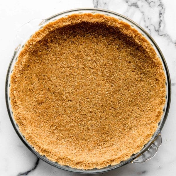 Picture of a graham cracker crust in a glass pie dish