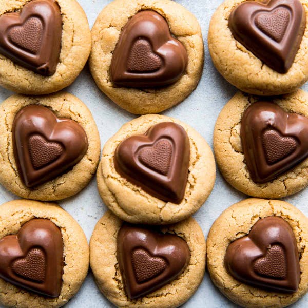 overhead view of peanut butter cookies with a chocolate heart candy pressed into their centers