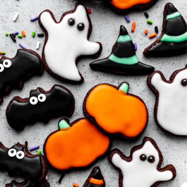 photo of halloween cut-out cookies decorated with icing: ghosts, witch hats, bats, and pumpkins