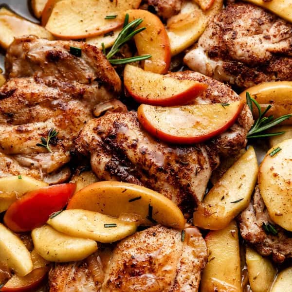spiced chicken thighs with cooked apple slices and fresh rosemaryy