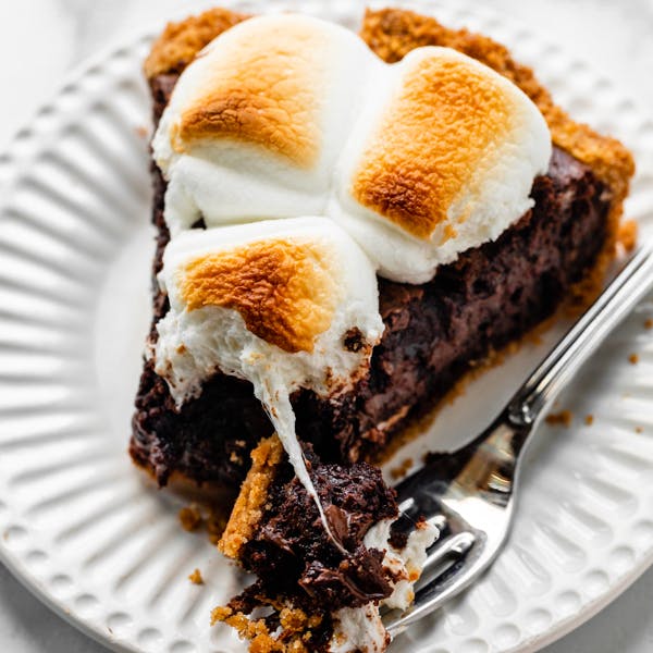 picture of a slice of s'more brownie pie with toasted marshmallows on top