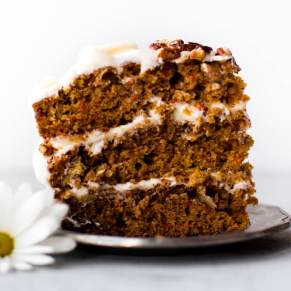 slice of three layer carrot cake on a metal plate