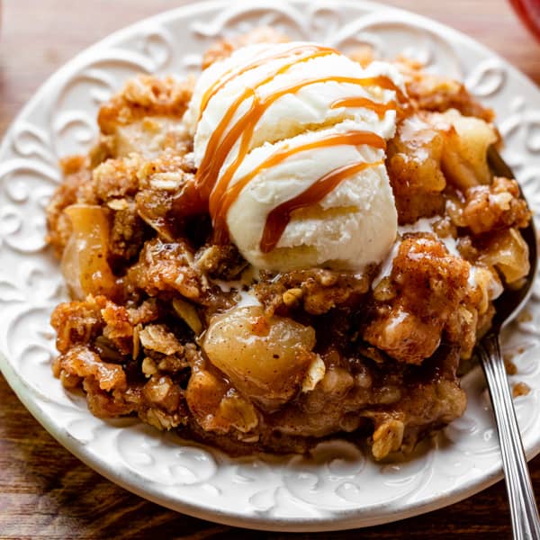 apple crisp on plate with vanilla ice cream and caramel