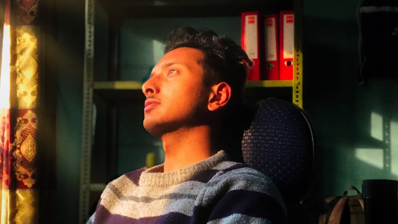 Suraj, staring outside the window at the setting sun