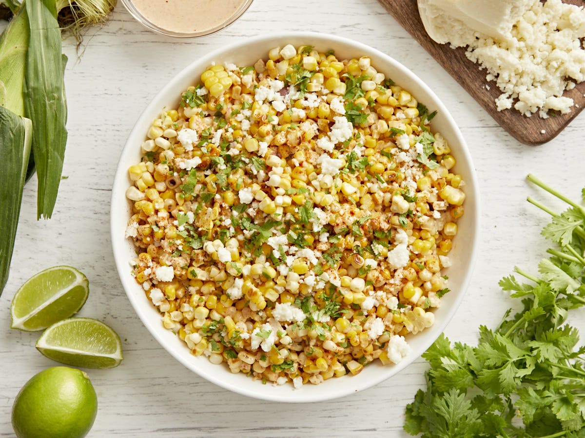 Side view of 7 layer dip with a hand holding a chip scooping some of the dip out.